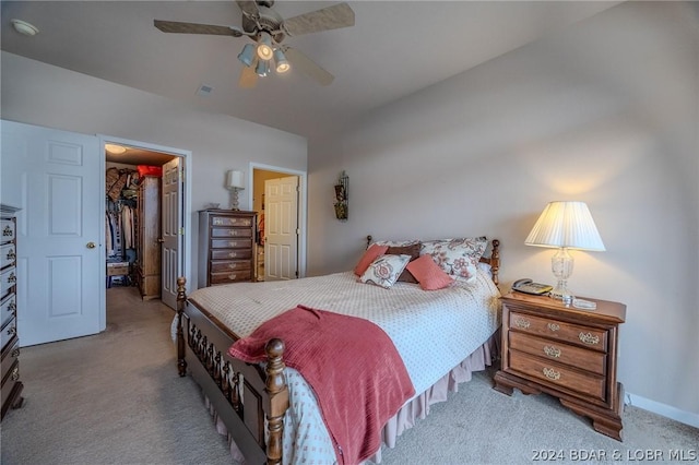 bedroom featuring ceiling fan, light colored carpet, a spacious closet, and a closet