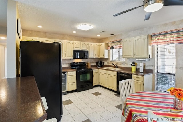 kitchen with a textured ceiling, black appliances, wine cooler, sink, and light tile patterned floors