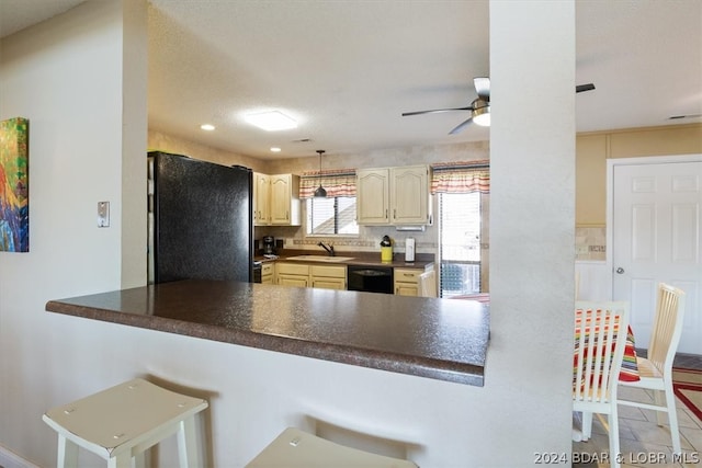 kitchen with black appliances, sink, a kitchen breakfast bar, kitchen peninsula, and ceiling fan