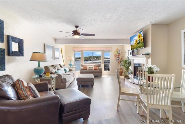 living room featuring hardwood / wood-style flooring, a textured ceiling, and ceiling fan