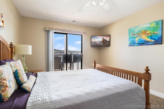 carpeted bedroom with ceiling fan, access to outside, and a textured ceiling