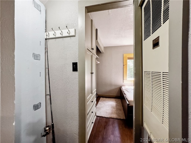 bathroom with wood-type flooring and a textured ceiling