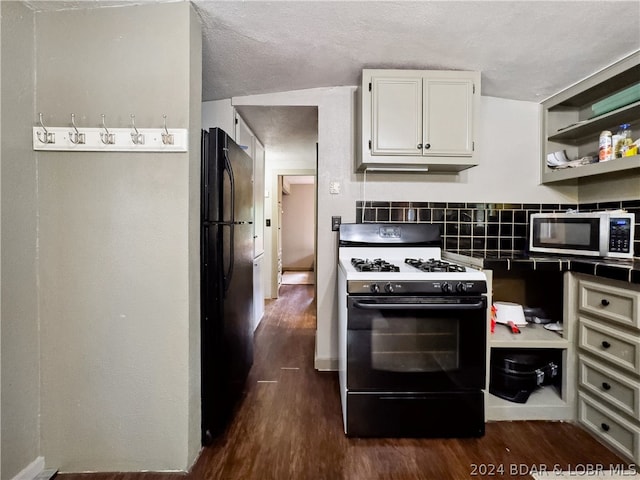 kitchen with dark hardwood / wood-style floors, black refrigerator, a textured ceiling, and range with gas cooktop