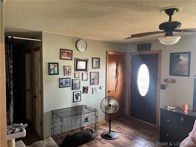 entryway featuring ceiling fan, dark hardwood / wood-style flooring, and a textured ceiling