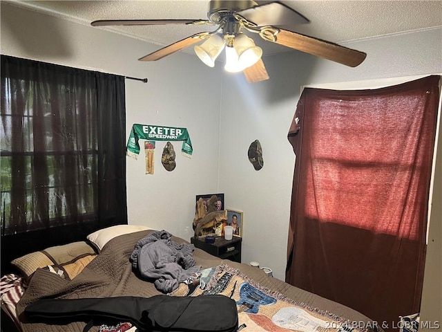 bedroom with a textured ceiling and ceiling fan