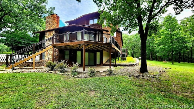 rear view of property with a wooden deck, a yard, and a patio area