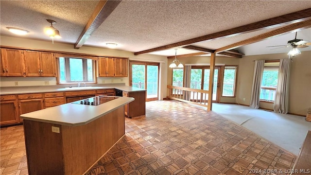 kitchen with pendant lighting, a wealth of natural light, black electric cooktop, and a center island