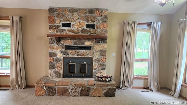 living room with carpet flooring, a wealth of natural light, and a fireplace