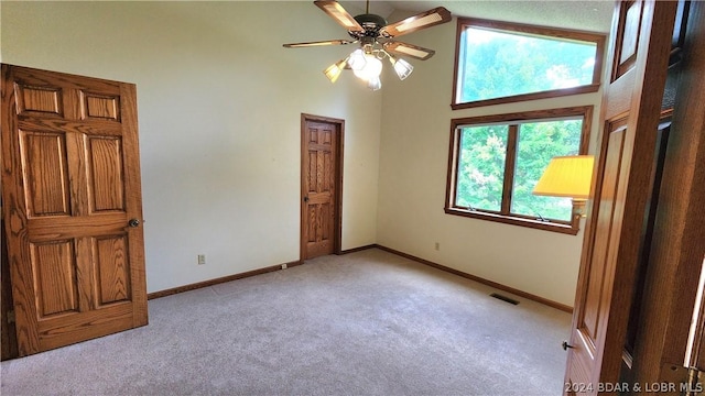 unfurnished bedroom featuring light colored carpet and a high ceiling