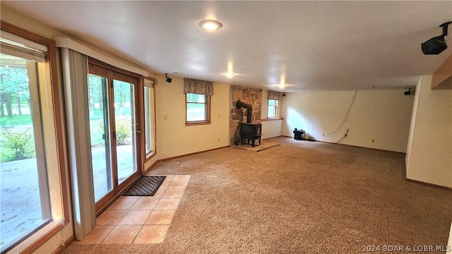 interior space with light carpet and a wood stove