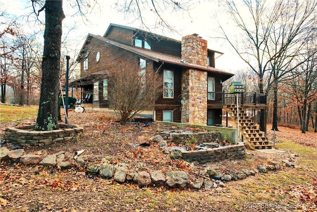 rear view of property featuring a garage and a wooden deck