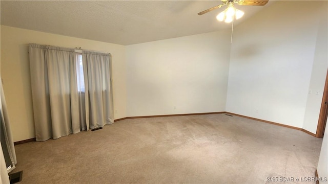 carpeted empty room featuring ceiling fan and a textured ceiling