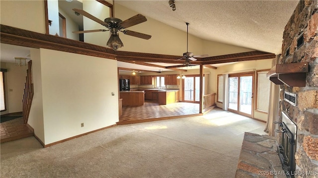 unfurnished living room featuring ceiling fan, a fireplace, light carpet, and a textured ceiling