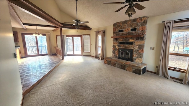 unfurnished living room with a fireplace, vaulted ceiling with beams, carpet, ceiling fan, and a textured ceiling