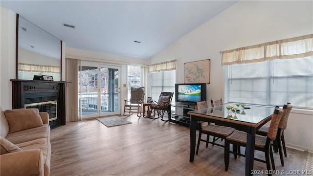 dining space with wood-type flooring and vaulted ceiling