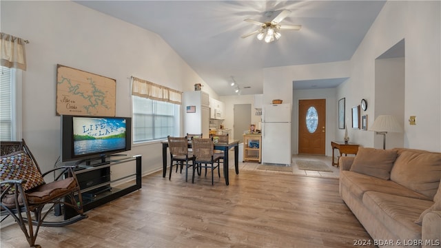 living room with ceiling fan, light wood-type flooring, and lofted ceiling