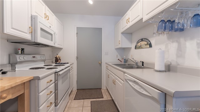 kitchen with white appliances, sink, light tile patterned floors, butcher block countertops, and white cabinetry