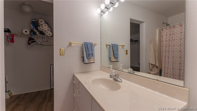 bathroom with wood-type flooring, vanity, and curtained shower