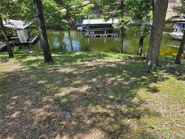 view of yard featuring a water view and a dock