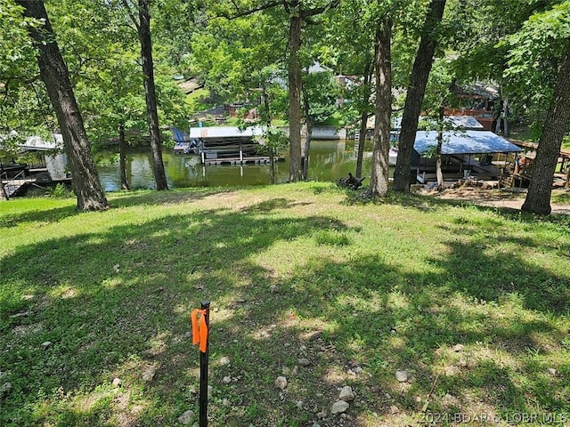 view of yard with a water view and a dock