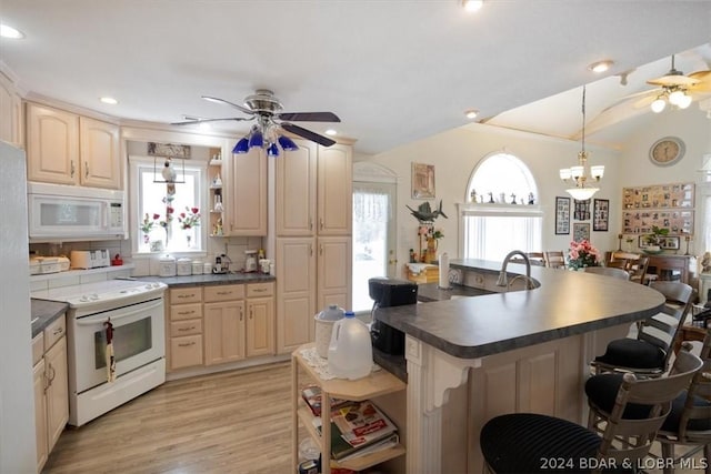 kitchen featuring tasteful backsplash, hanging light fixtures, light hardwood / wood-style flooring, white appliances, and ceiling fan with notable chandelier