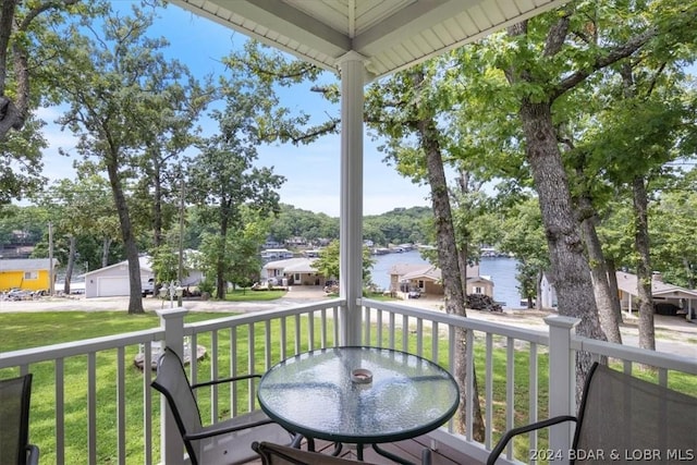 balcony featuring a water view and a porch