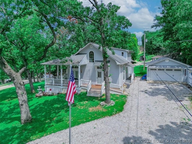 view of front of house with a porch, a garage, an outdoor structure, and a front yard