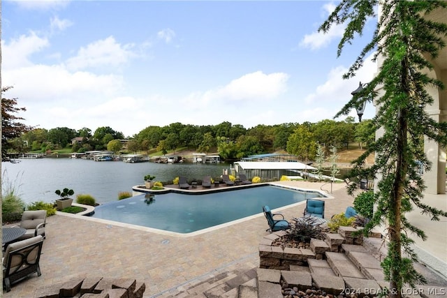 view of pool with a water view and a patio