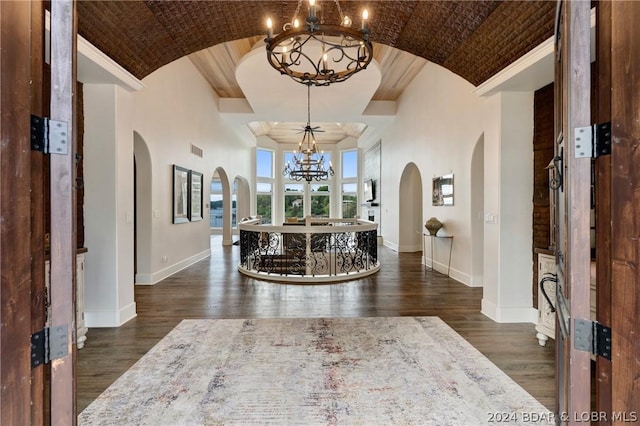 entryway featuring brick ceiling, dark hardwood / wood-style flooring, an inviting chandelier, and high vaulted ceiling