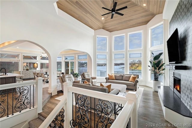 living room featuring a fireplace, wood-type flooring, wood ceiling, and a wealth of natural light