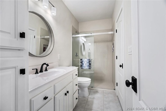 bathroom with tile patterned floors, toilet, vanity, and walk in shower