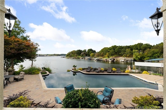 view of pool featuring a patio area and a water view