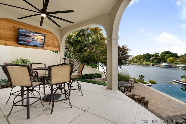 view of patio / terrace with ceiling fan and a water view