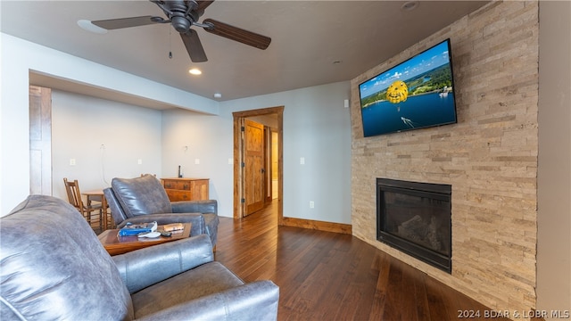 living room featuring dark hardwood / wood-style flooring, a fireplace, and ceiling fan