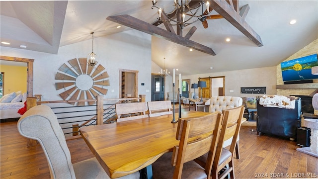 dining space with hardwood / wood-style flooring, vaulted ceiling, and a chandelier