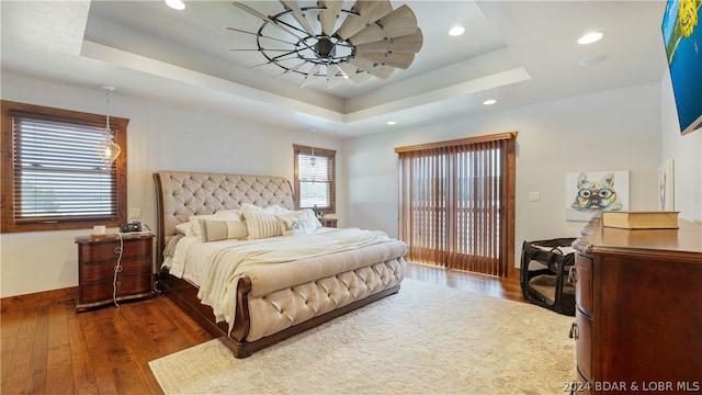 bedroom with dark wood-type flooring and a raised ceiling