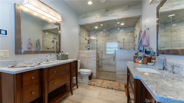 bathroom featuring vanity, a shower with door, tile patterned flooring, and toilet