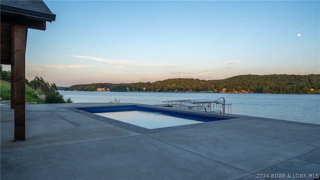 pool at dusk featuring a patio area