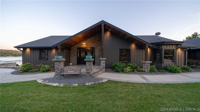 view of front of property with a water view and a yard