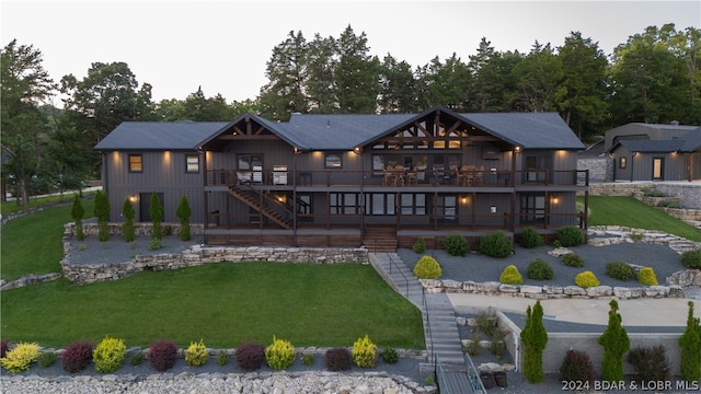 back of house featuring a deck, a patio area, and a yard