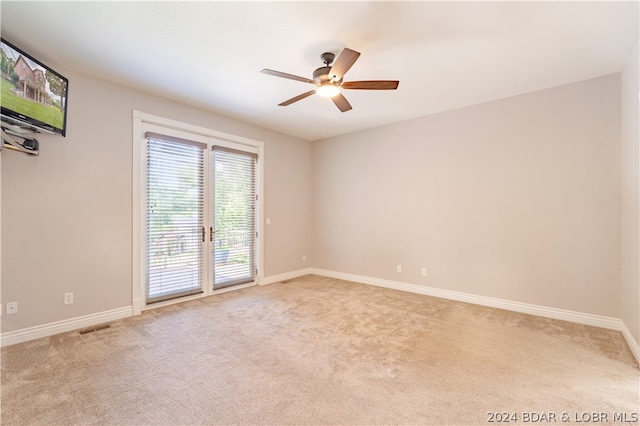 empty room featuring light colored carpet and ceiling fan