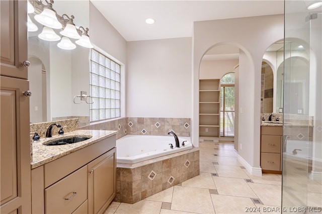 bathroom with tile patterned floors, vanity, and a healthy amount of sunlight