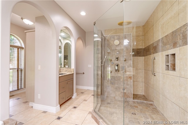 bathroom with vanity, a shower with door, and tile patterned flooring