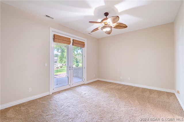 carpeted spare room featuring french doors and ceiling fan