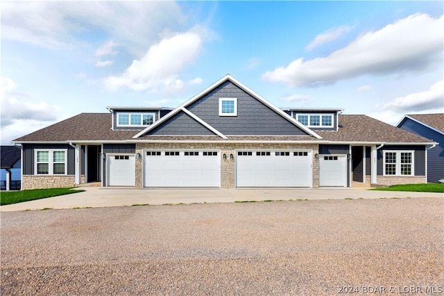 view of front of property featuring stone siding and roof with shingles