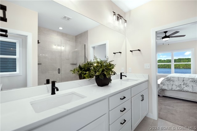 bathroom with tile patterned flooring, ceiling fan, a shower with shower door, and vanity