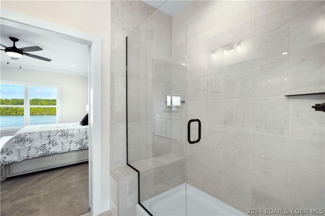 bathroom with ceiling fan, a water view, and a shower with door