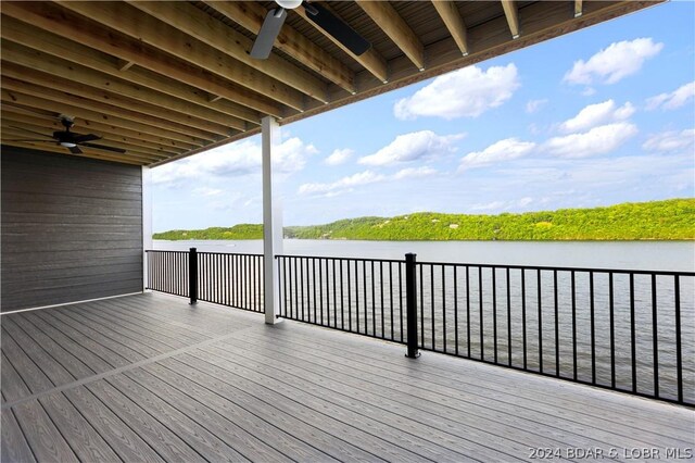 wooden terrace with a water view and ceiling fan