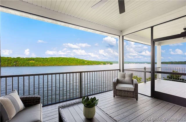 wooden terrace with a water view and ceiling fan