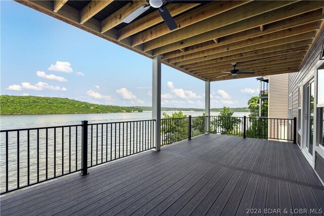 deck with ceiling fan and a water view